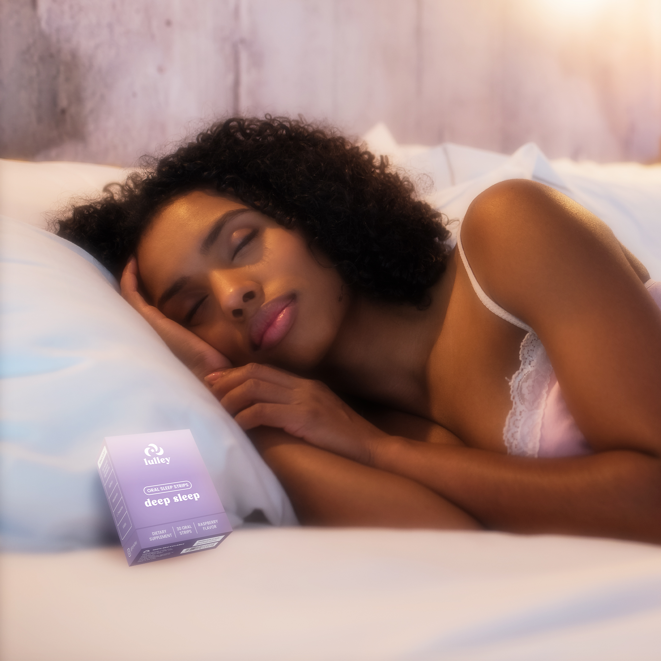 Woman sleeping peacefully on a bed with a sleep supplement box nearby.