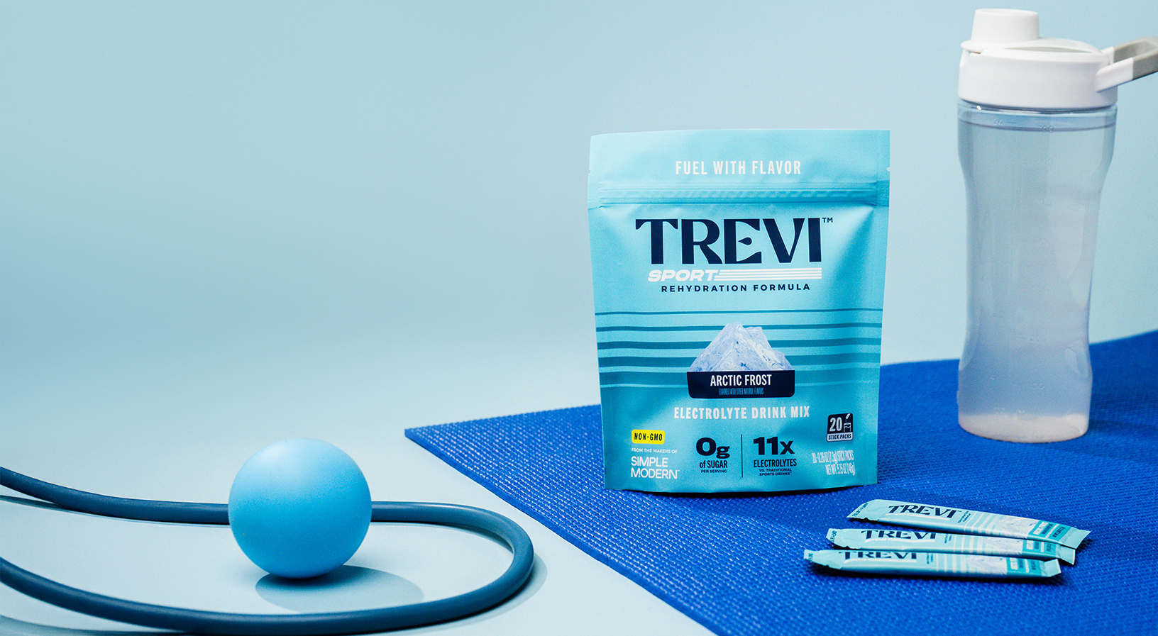 Trevi electrolyte drink mix package surrounded by lemons against a blue sky.