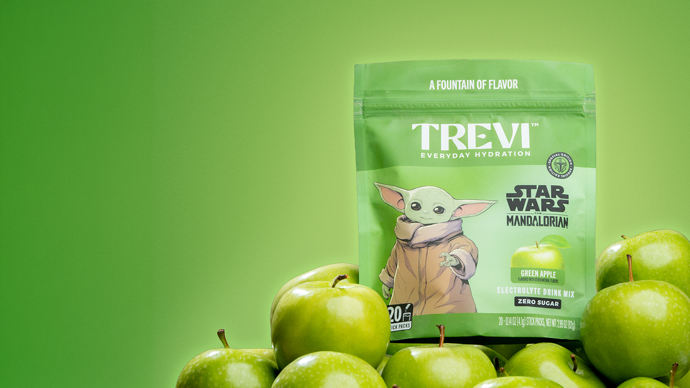 Trevi electrolyte drink mix package surrounded by lemons against a blue sky.