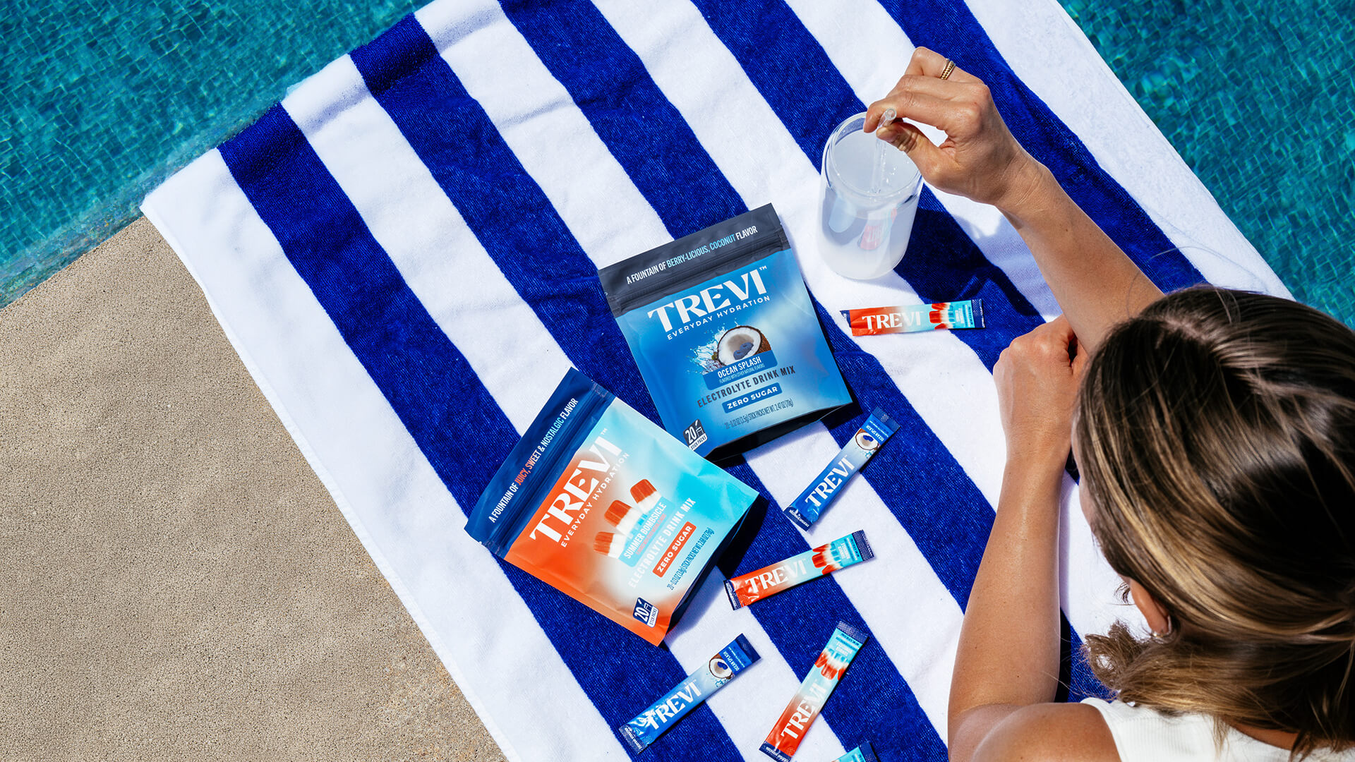 Trevi electrolyte drink mix package surrounded by lemons against a blue sky.