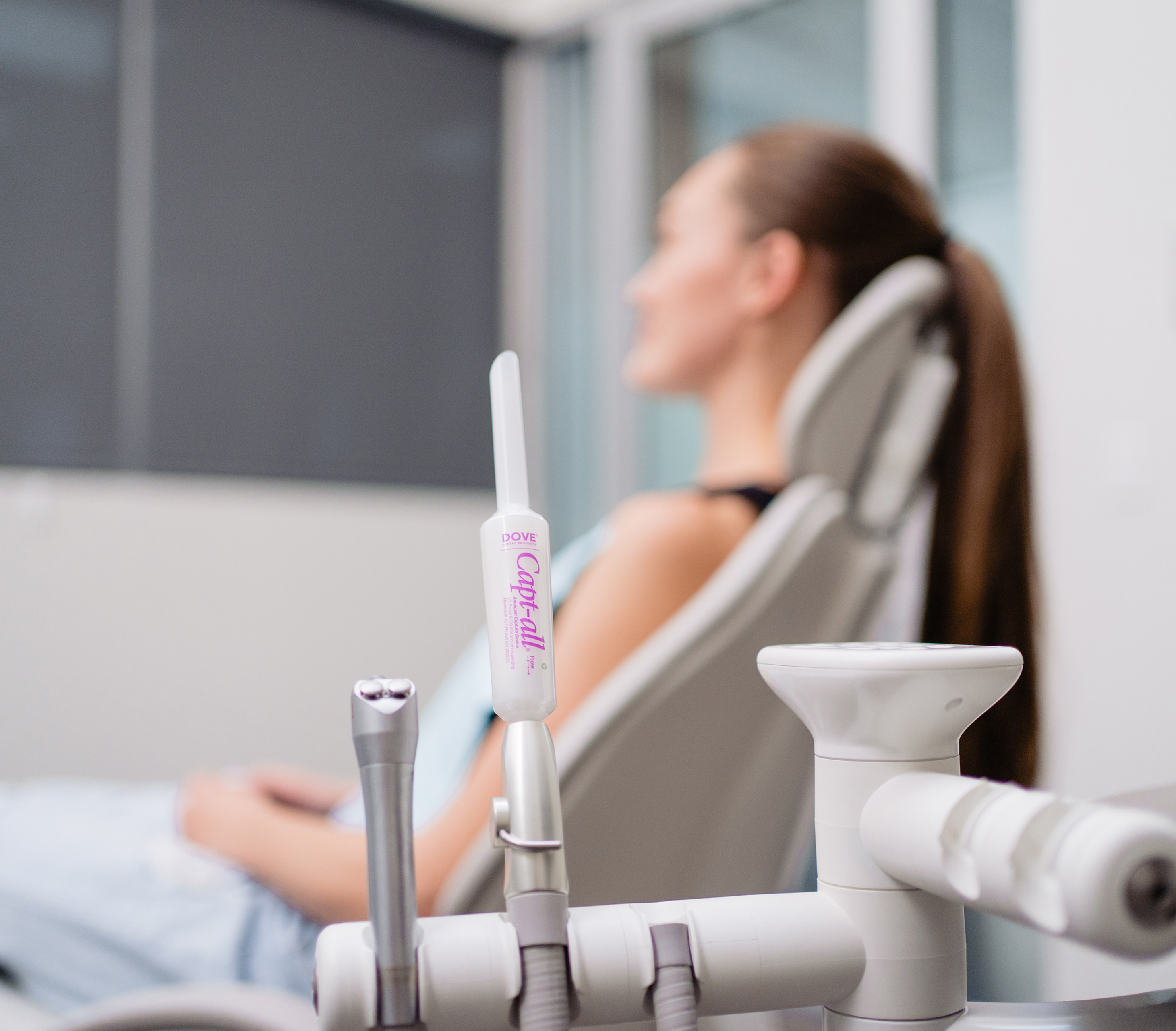 Dental tools in focus with a patient in the background.