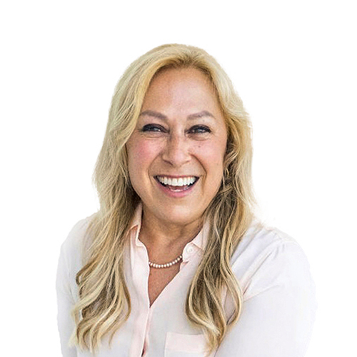 A headshot of a smiling woman with long blonde hair wearing a collared shirt and pearl necklace.