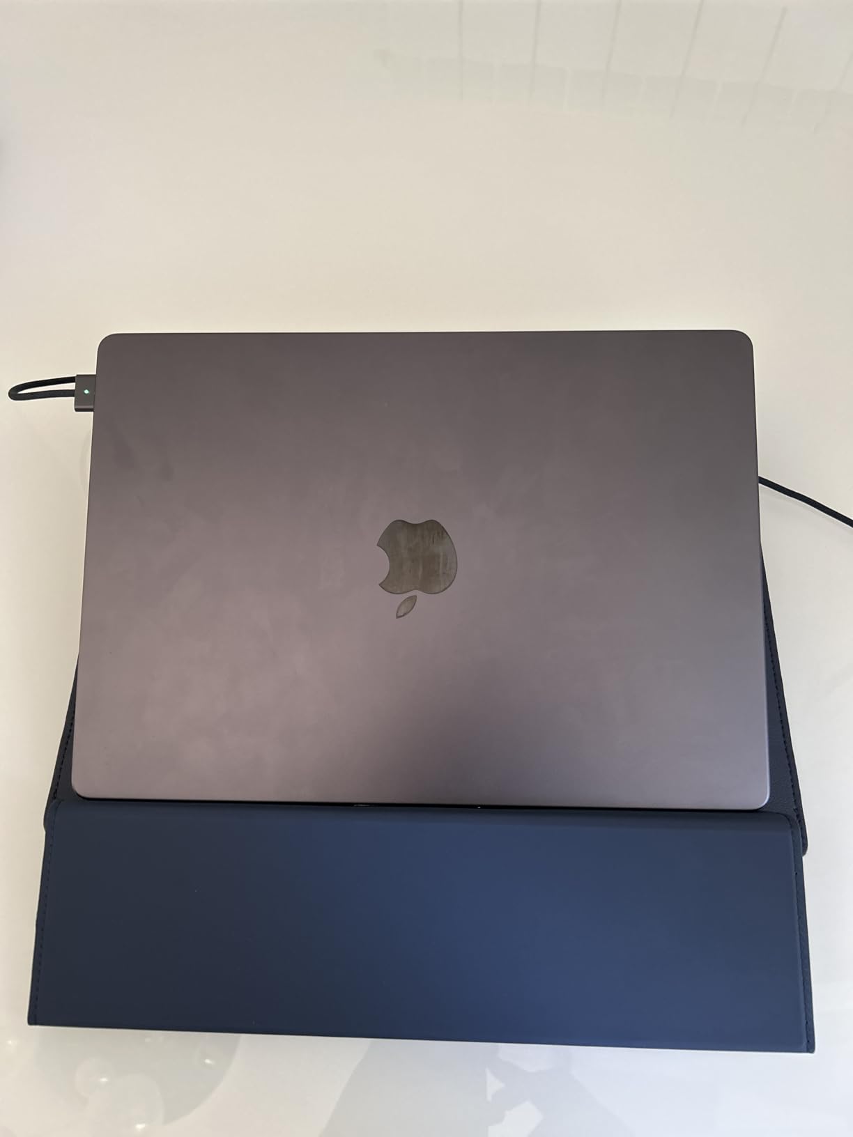 Closed laptop with an apple logo on a white surface.
