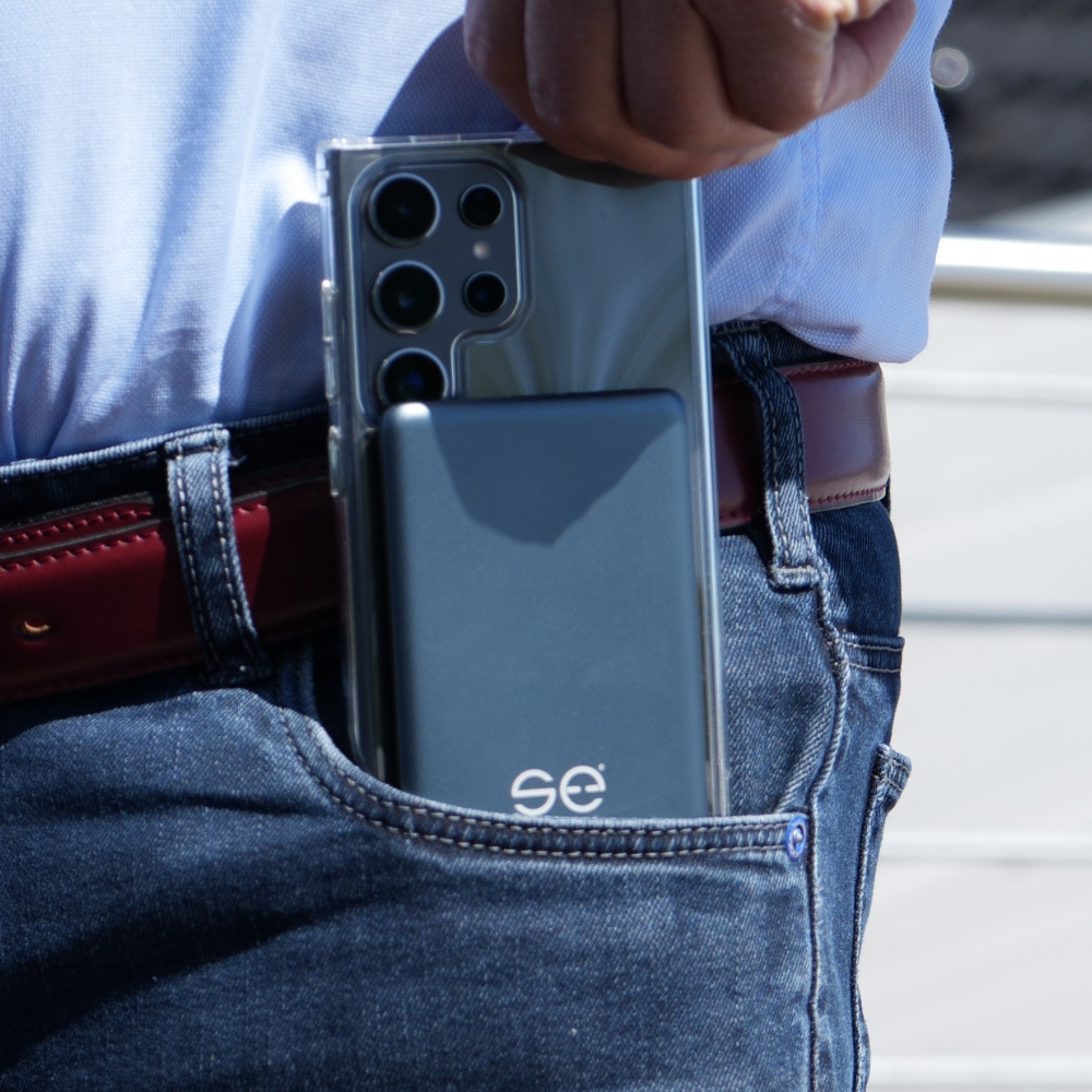 A person placing a smartphone with multiple cameras into a jeans pocket.