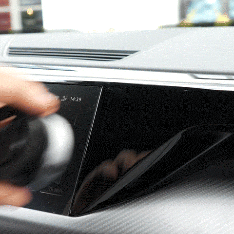 Hand adjusting a car's touchscreen display with a rotary knob.