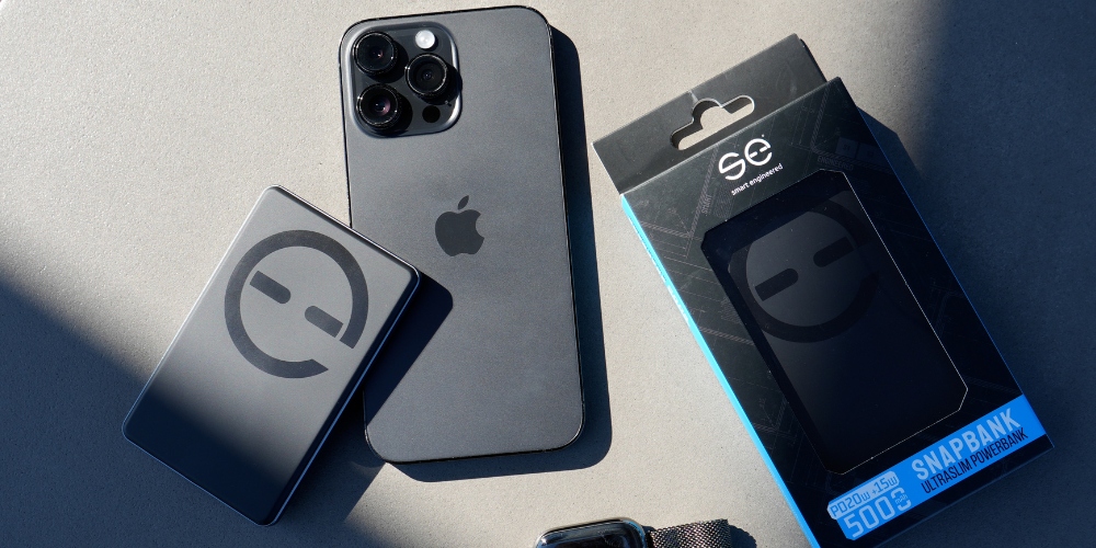 Smartphone, power bank, and packaging on a gray surface.