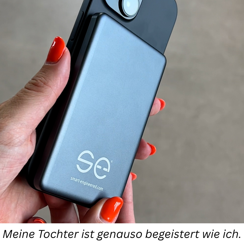 Hand holding a smartphone with a gray case and red nails.