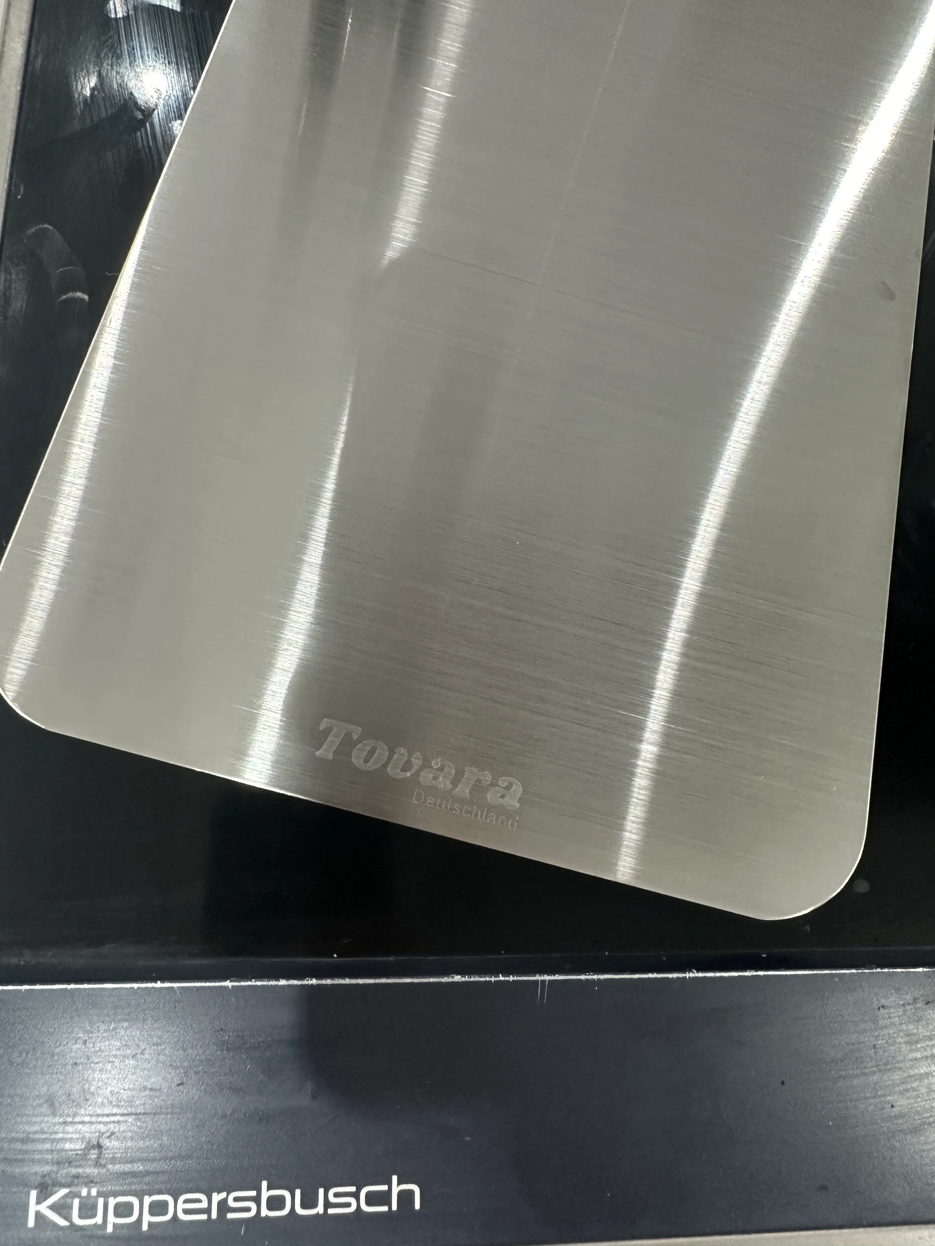 Metal surface with engraved Tovara Deutschland logo, Küppersbusch text below.