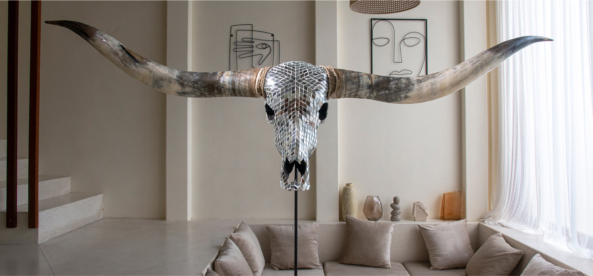 Decorative mirrored bull skull with long horns in a modern living room.