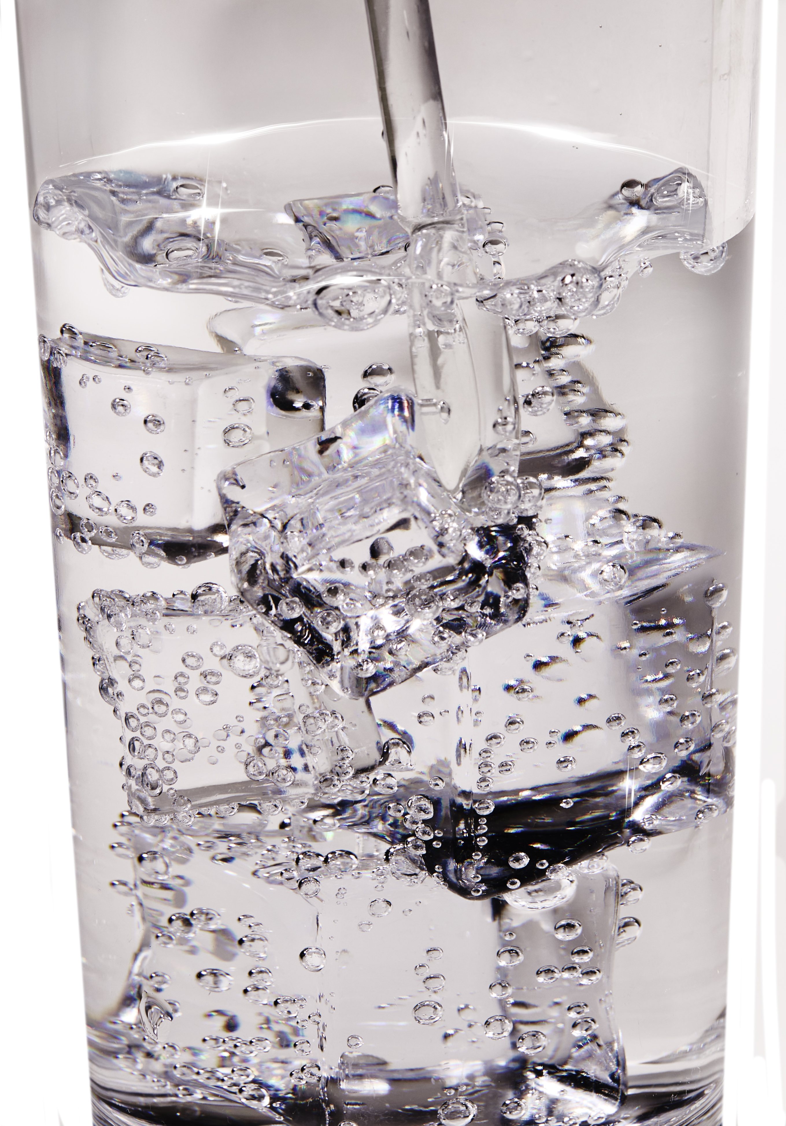 Close-up of ice cubes and bubbles in a clear liquid.