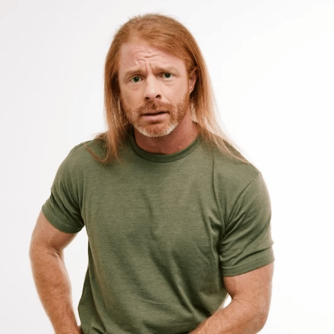 Man with long hair and beard wearing a green t-shirt on a white background.