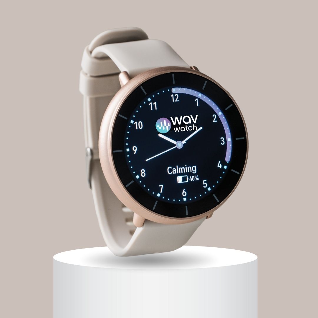 Smartwatch with round face displaying time and battery percentage on a beige background.