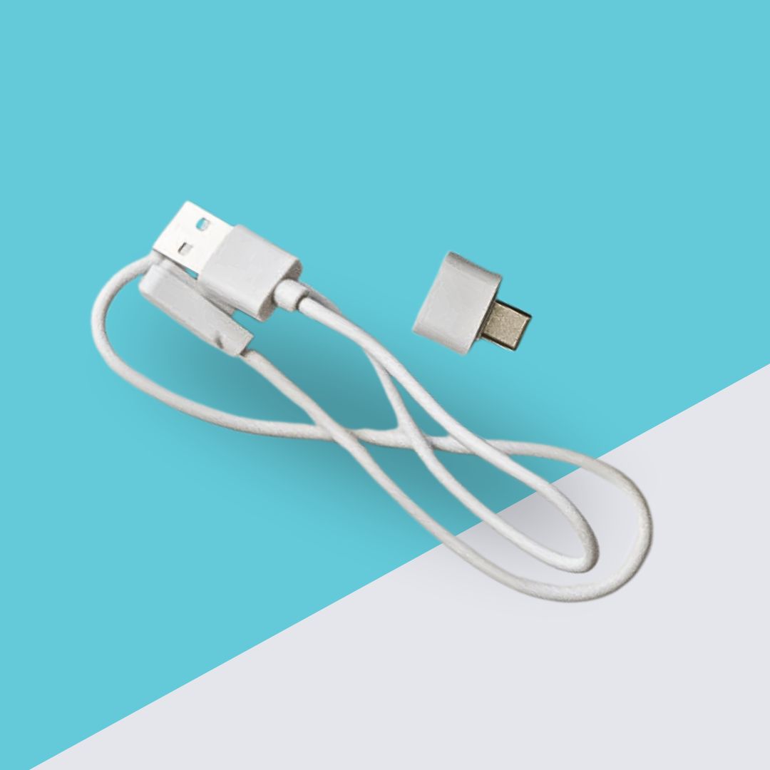 A white USB charging cable with a detachable adapter tip lies on a blue and white background.