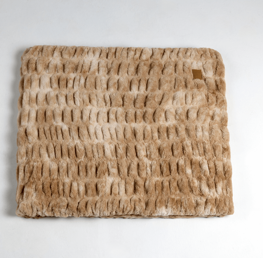 Textured brown fur throw placed on a flat surface.