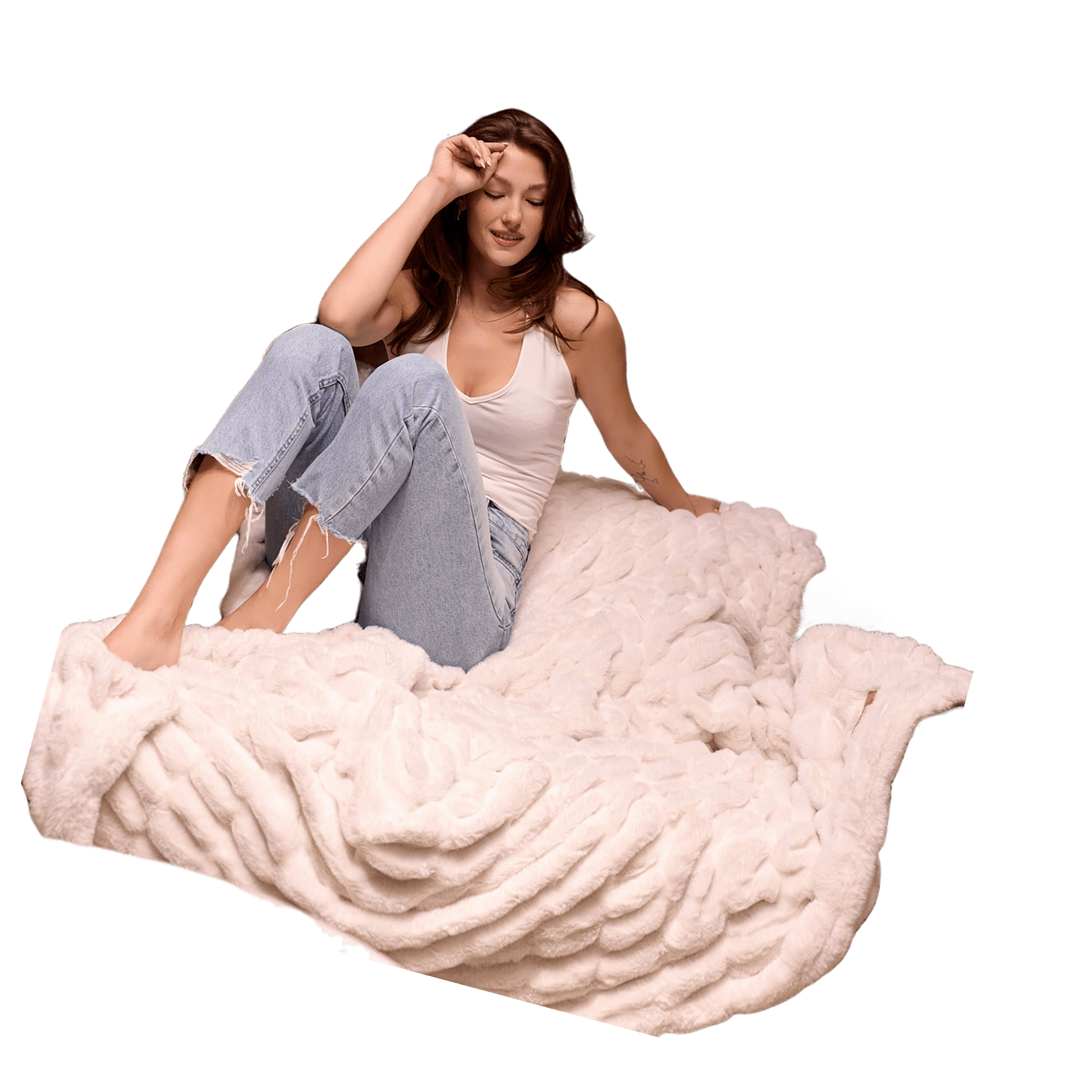 Person in jeans and a tank top sitting on a fluffy white blanket.