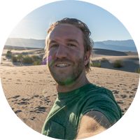 Person taking a selfie in a desert landscape with sand dunes.