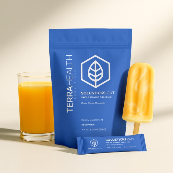 Blue drink mix package, orange popsicle, and glass of orange juice.