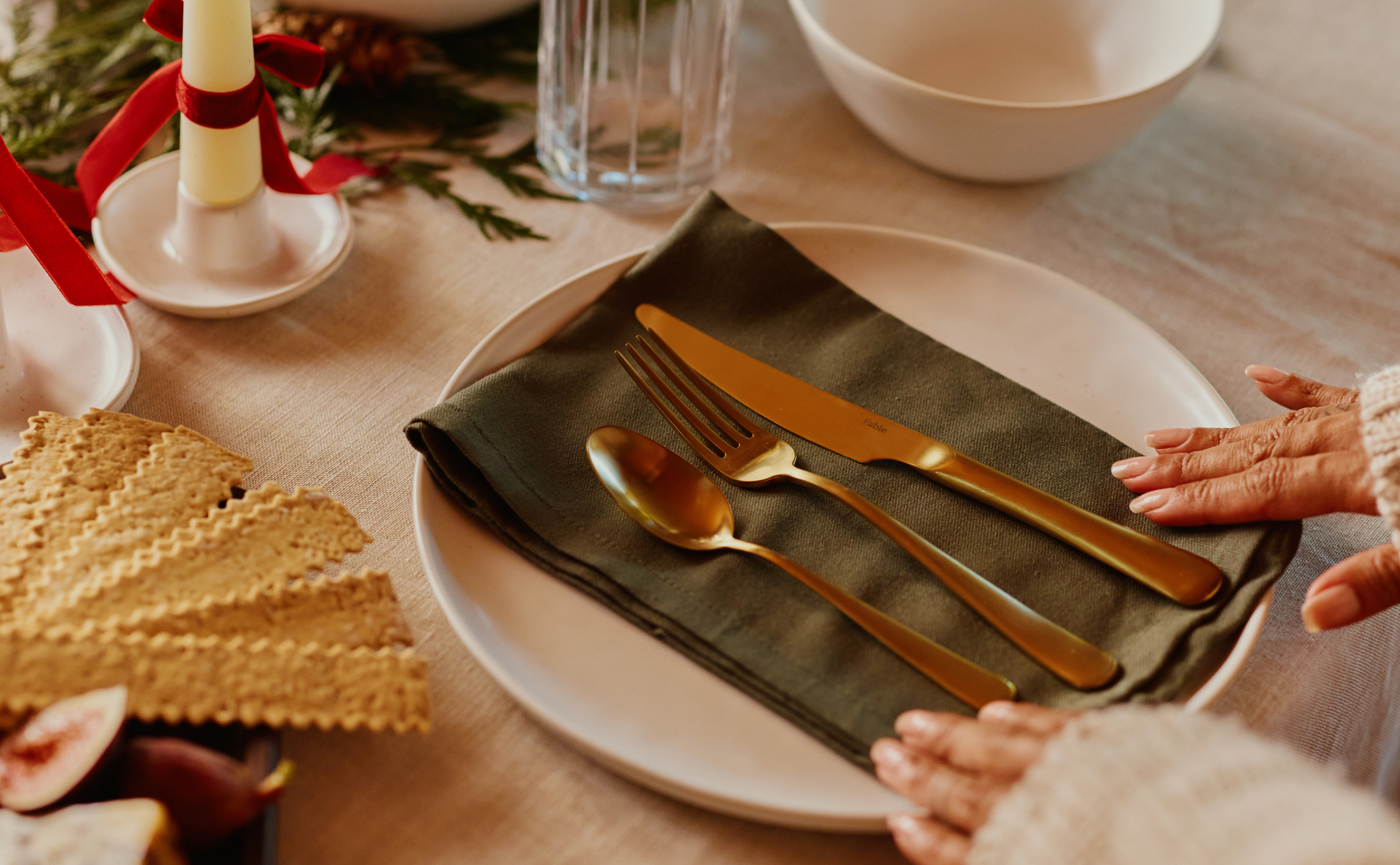 Place setting with gold cutlery on a green napkin and a white plate