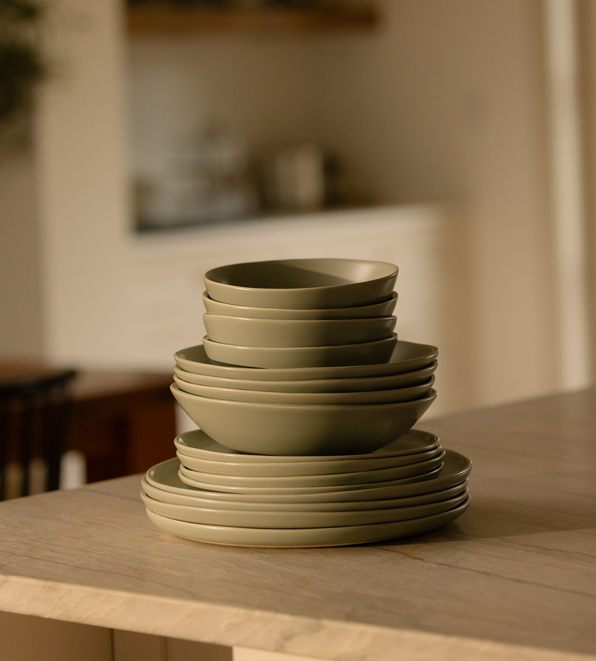 Stack of green bowls and plates on a kitchen counter.