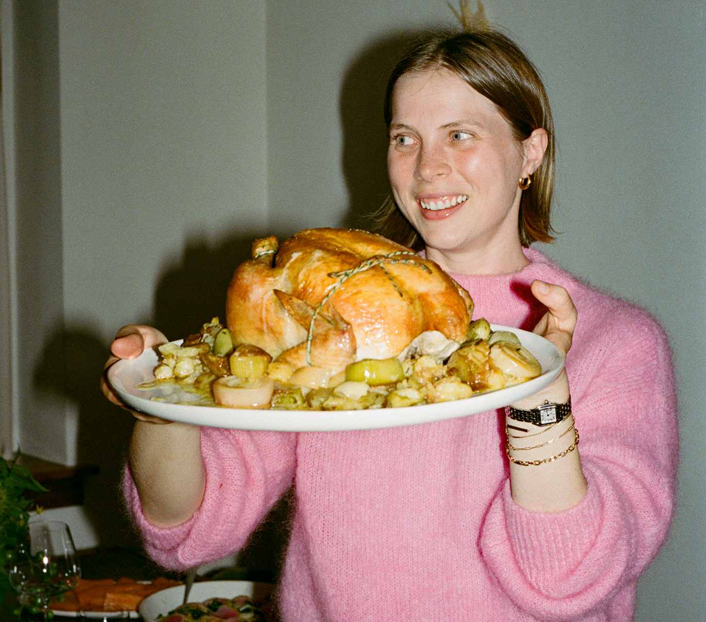 Person holding a plate with roasted poultry and vegetables.