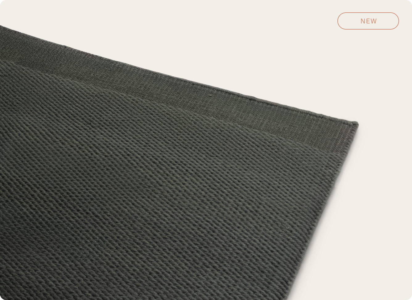 Close-up of a textured dark gray fabric with a label saying 'NEW'.