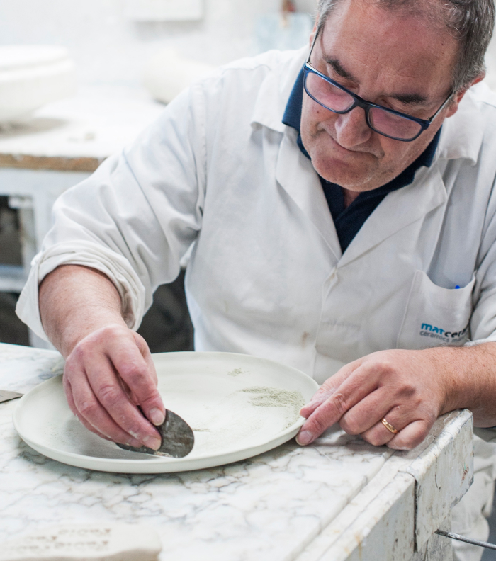 A man is making a dinnerplate by hand.