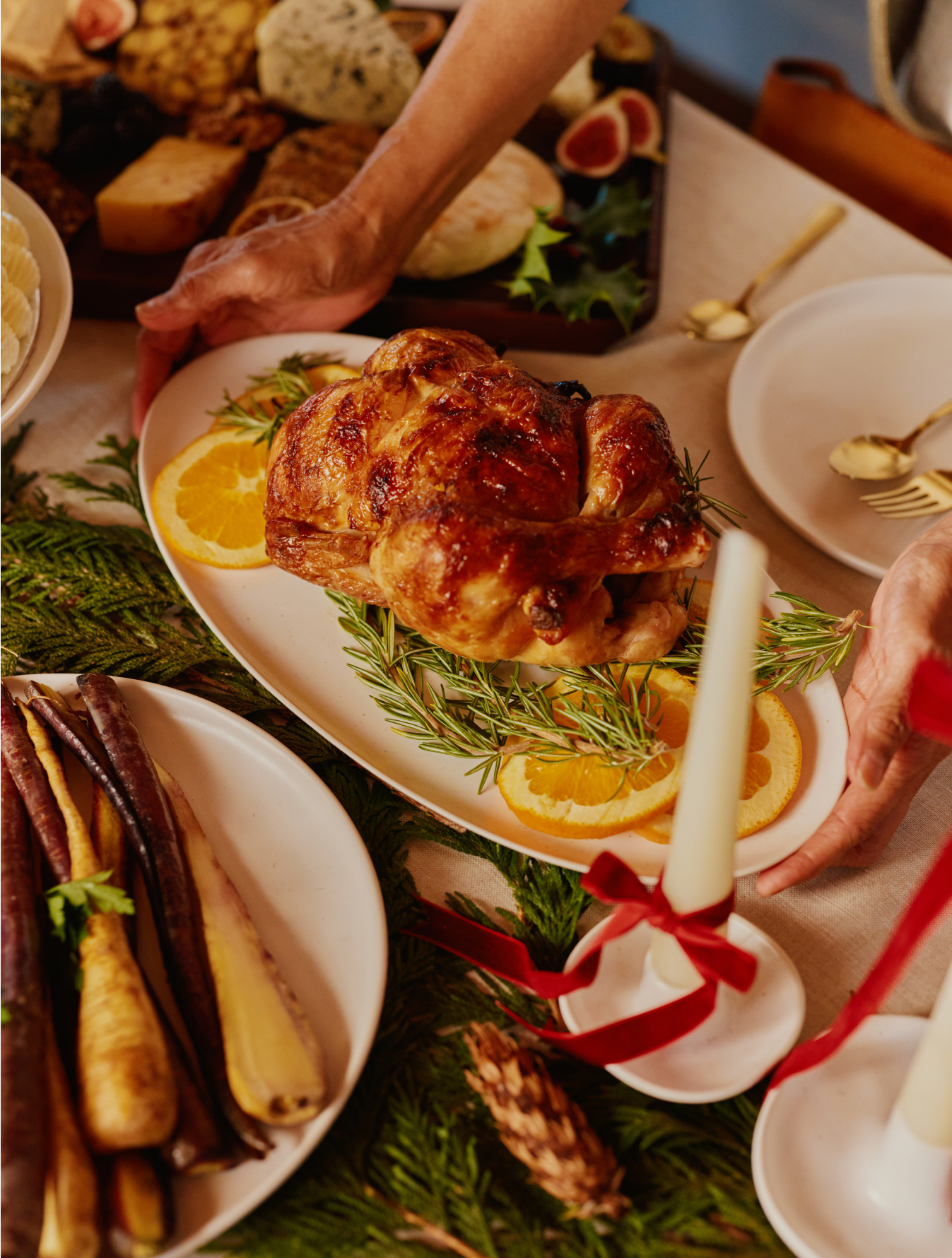 Roast chicken on a platter with orange slices and rosemary