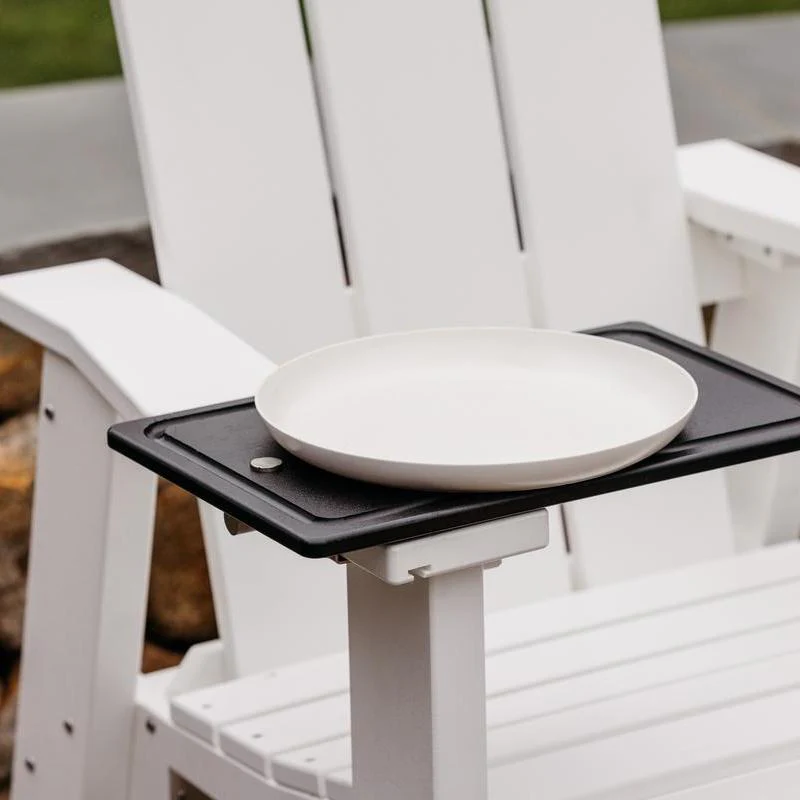 White plate on a black tray attached to a white outdoor chair.