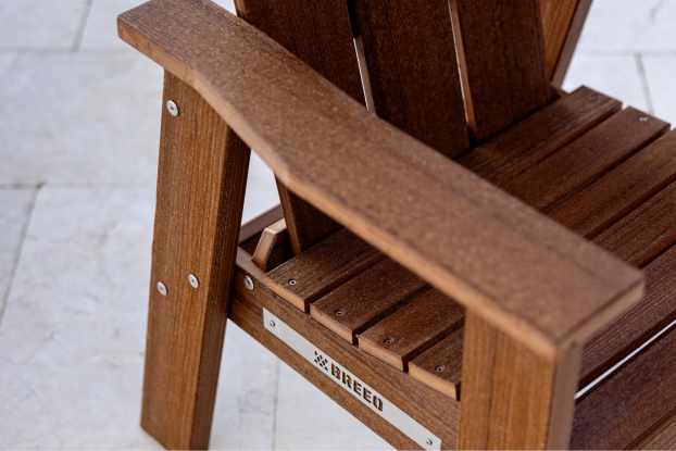 Close-up of a wooden chair armrest with visible screws and a 'Breeo' label.