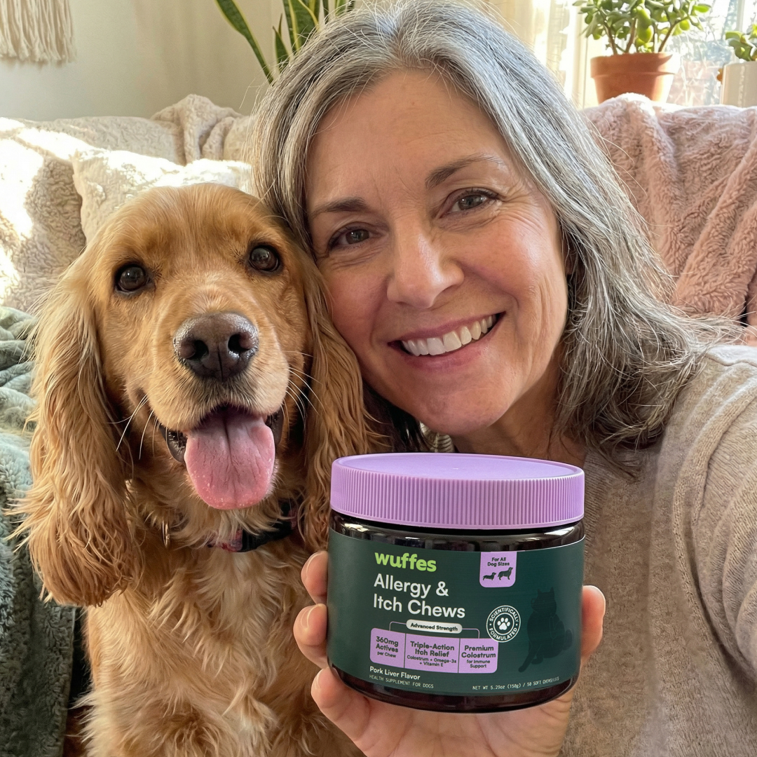 A smiling woman with her dog holds up a jar of Wuffes Allergy & Itch Chews.
