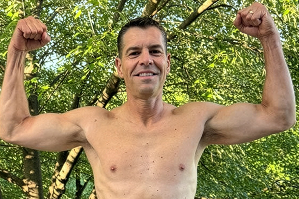 A smiling female doctor with a stethoscope around her neck is examining a patient.