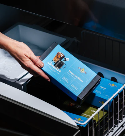 Hand placing a blue coffee package into a drawer.