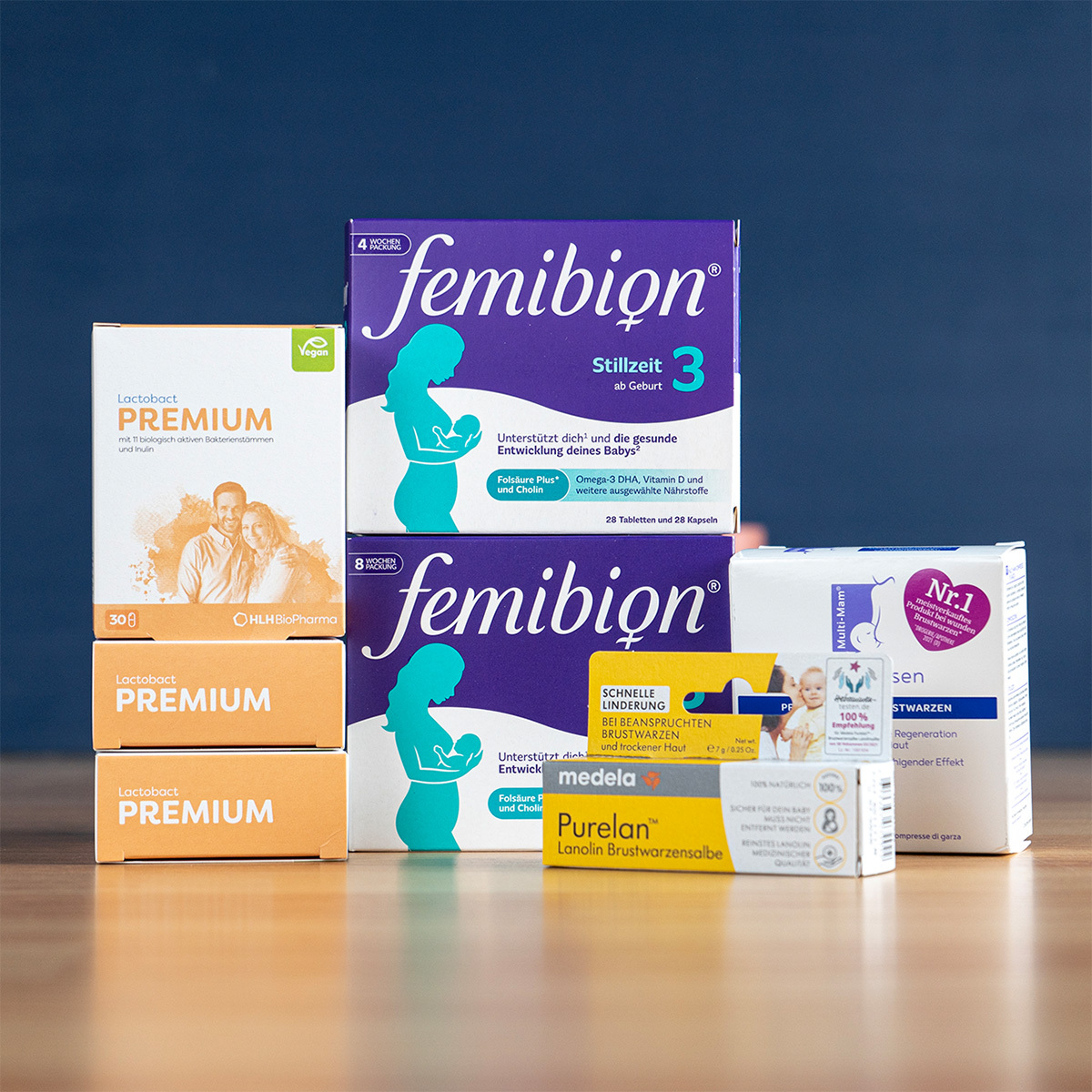 Boxes of Femibion and Folio nausema pregnancy supplements stacked on a wooden counter in a pharmacy.