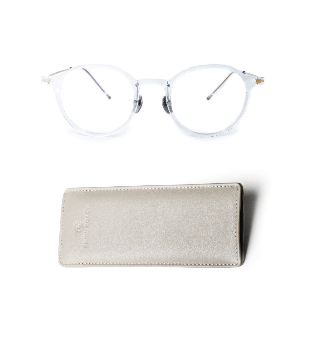 A pair of clear-framed eyeglasses with thin metal arms, shown above a light-colored leather case.
