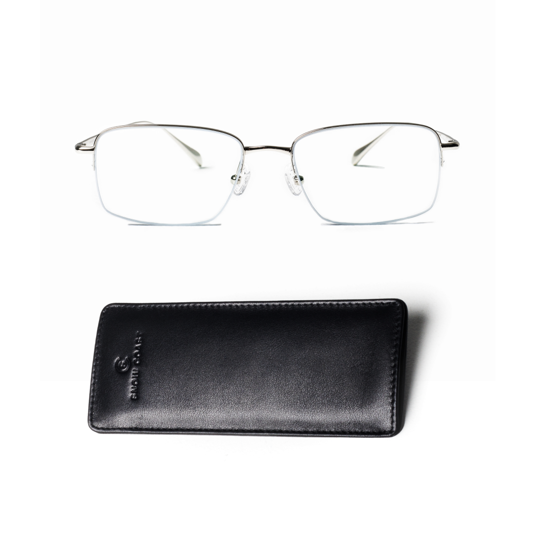 Silver half-rim eyeglasses and a black case on a white background.