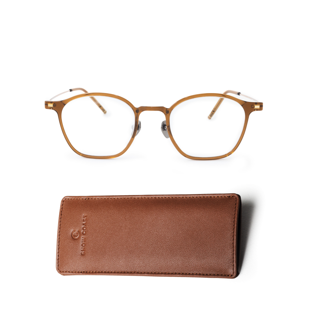 A pair of brown, round-framed eyeglasses above a brown leather case on a white background.