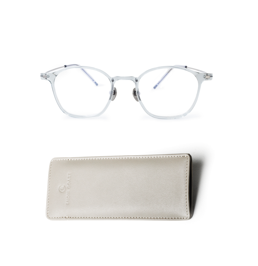 A pair of light blue, translucent-framed eyeglasses sits above a light gray leather case on a white background.