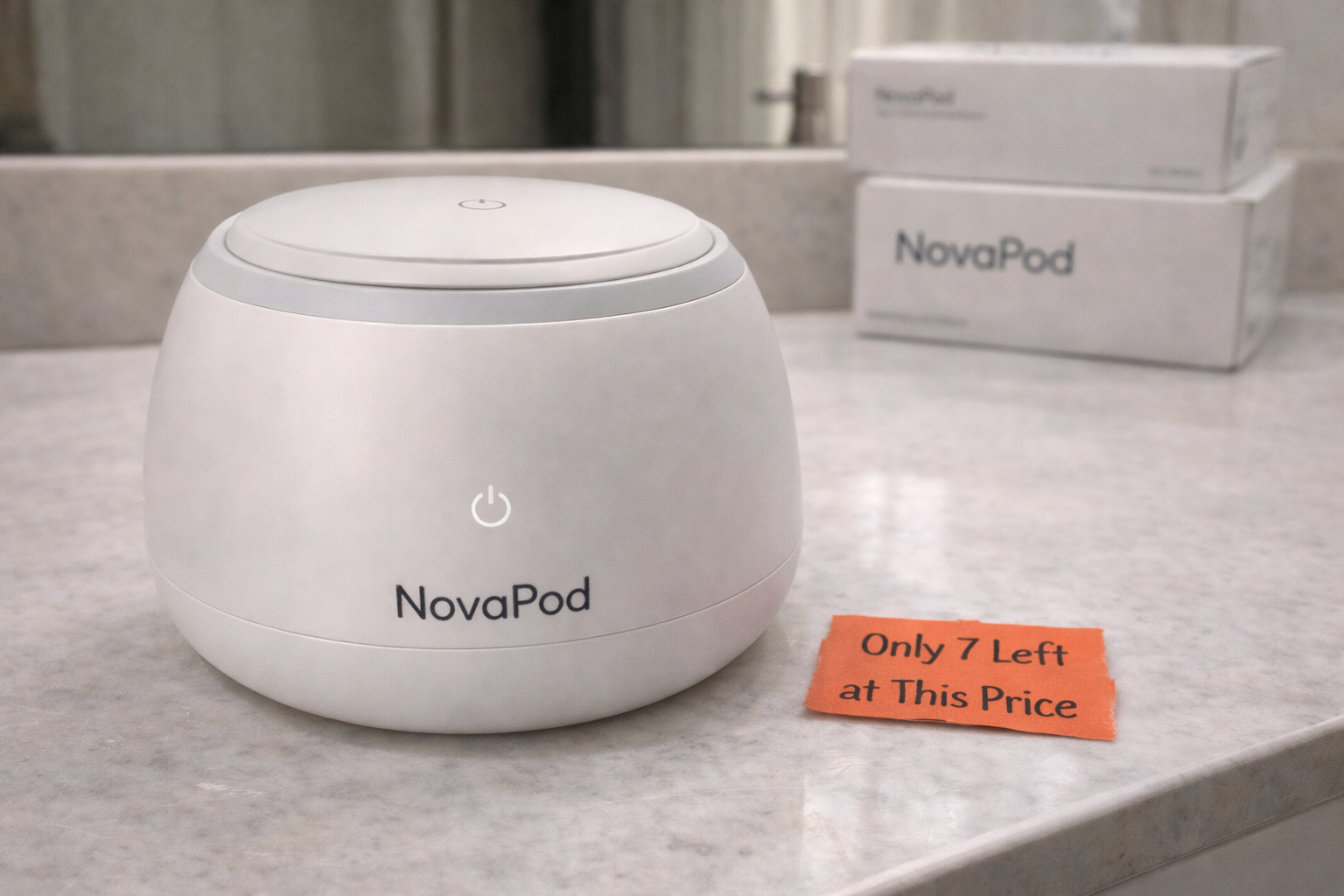 A white NovaPod device on a marble countertop with its packaging and a small orange sale sign.