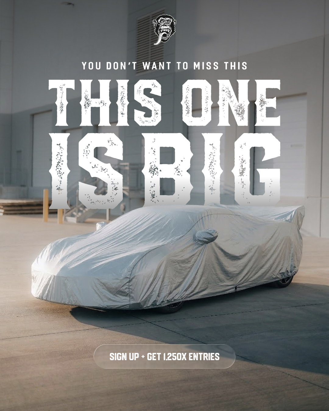 A sports car is concealed under a silver car cover in a promotional image.