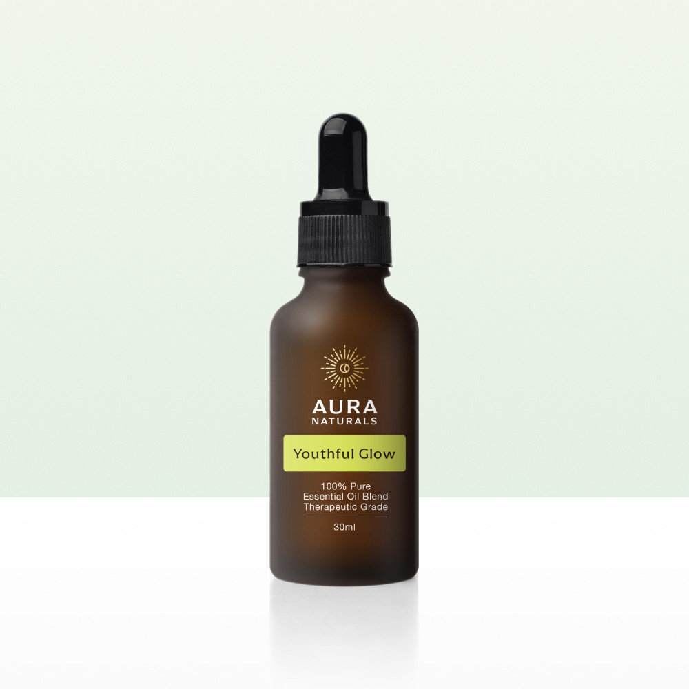 A brown dropper bottle of Aura Naturals Youthful Glow essential oil on a white and light green background.