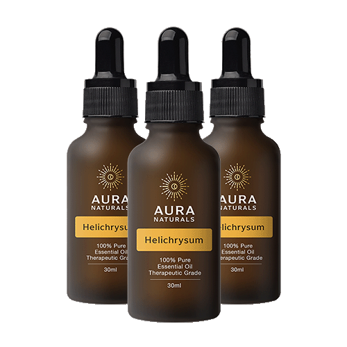 Three brown glass dropper bottles of Aura Naturals Helichrysum essential oil against a solid green background.