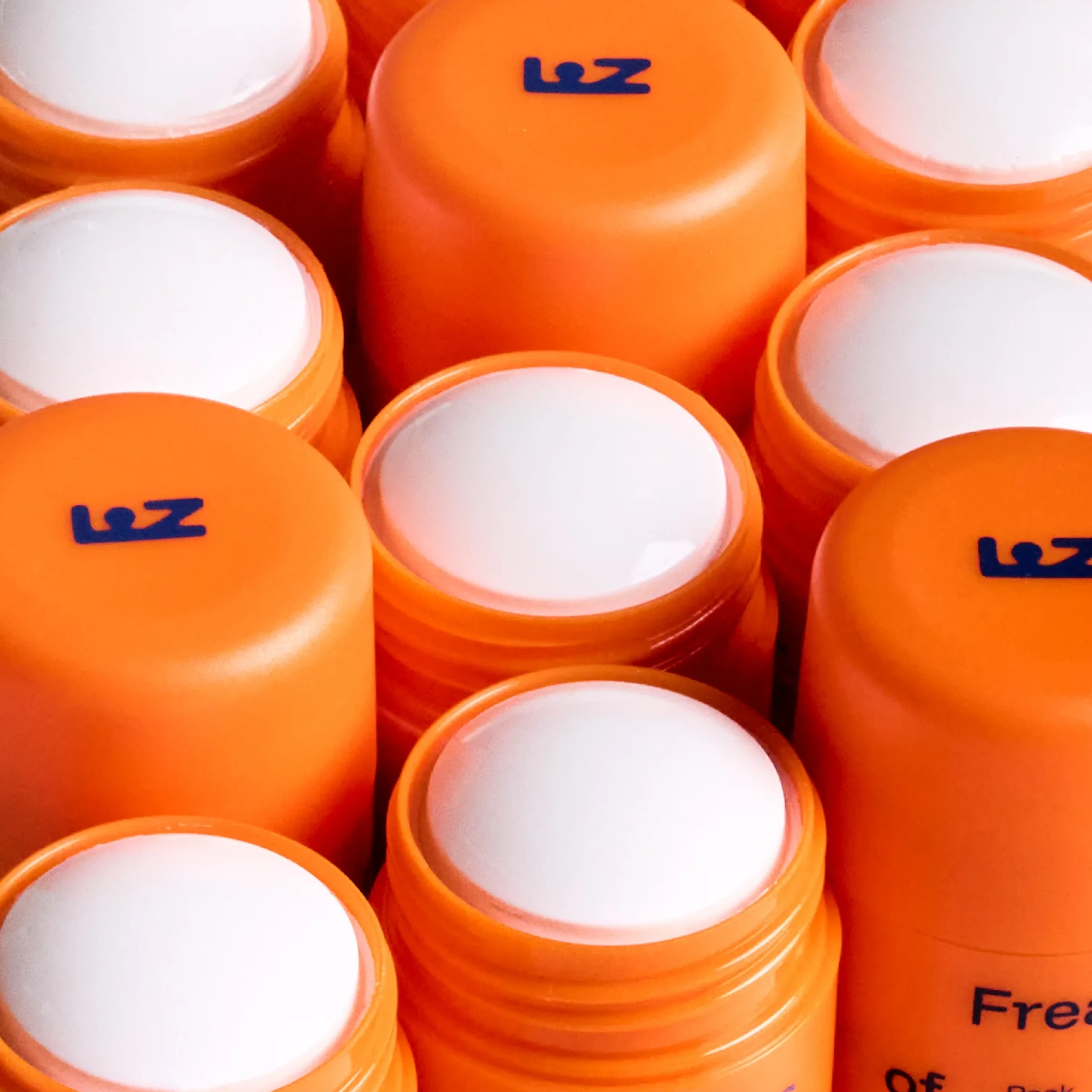 Close-up of orange deodorant sticks with white tops.