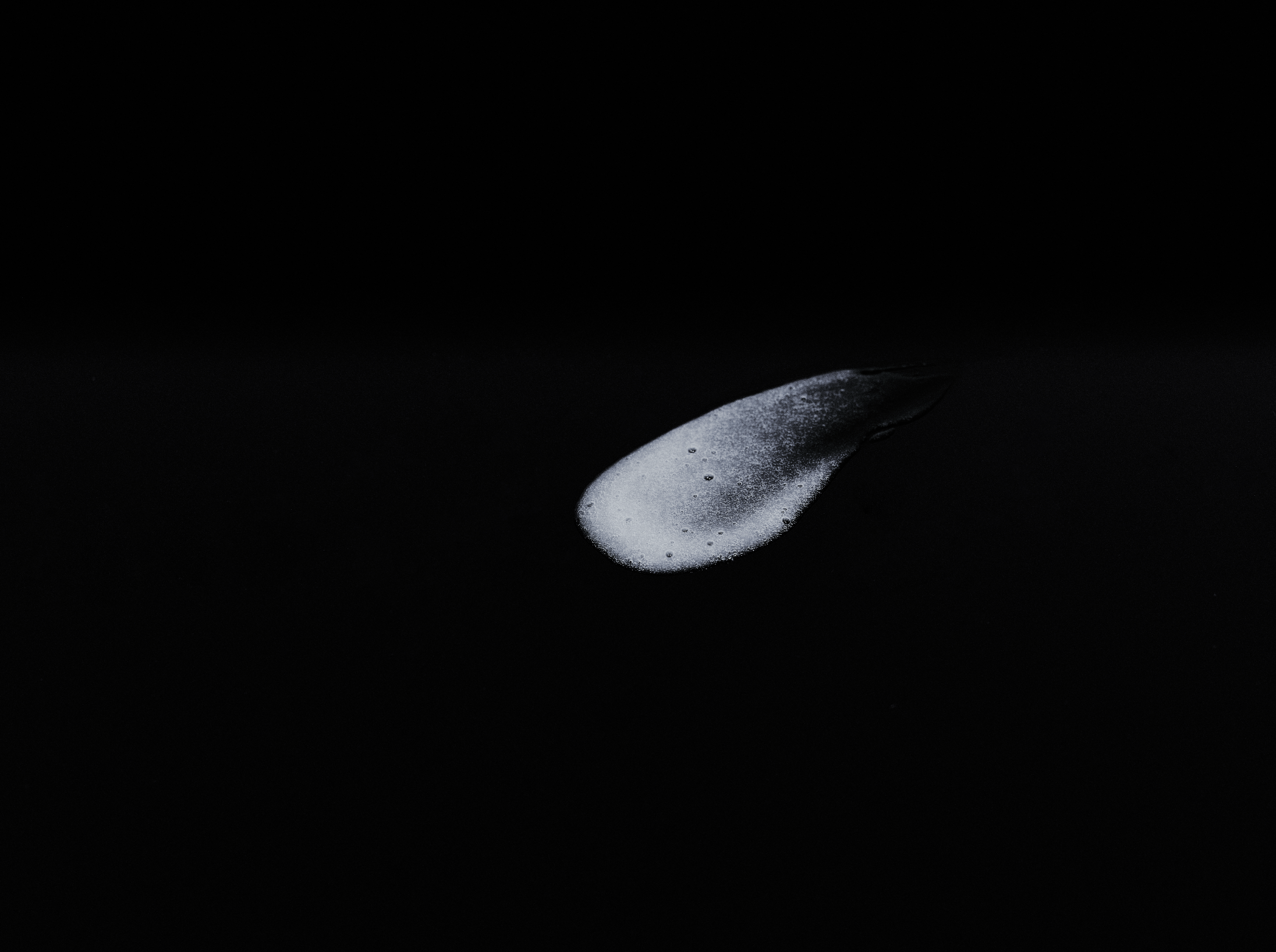 White brush stroke on a black background.