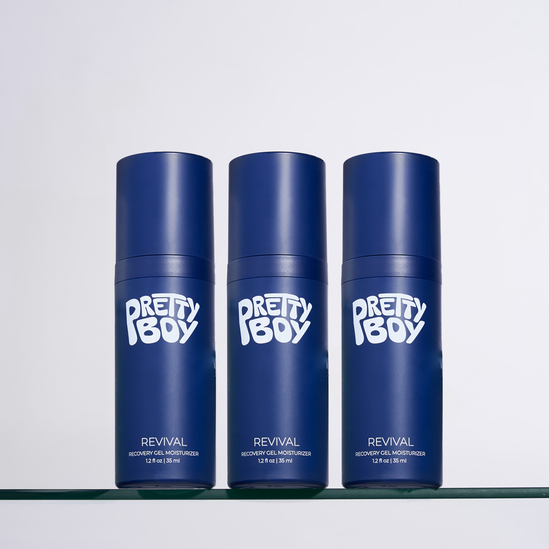 Three blue bottles of Pretty Boy Revival Recovery Gel Moisturizer sitting in a row on a shelf.
