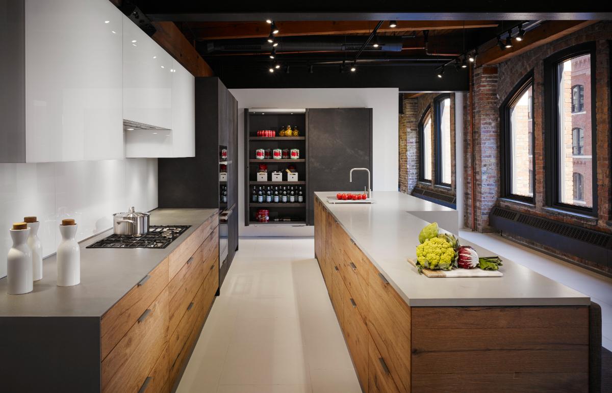 Modern kitchen with wooden cabinets, white countertops, and exposed brick walls.