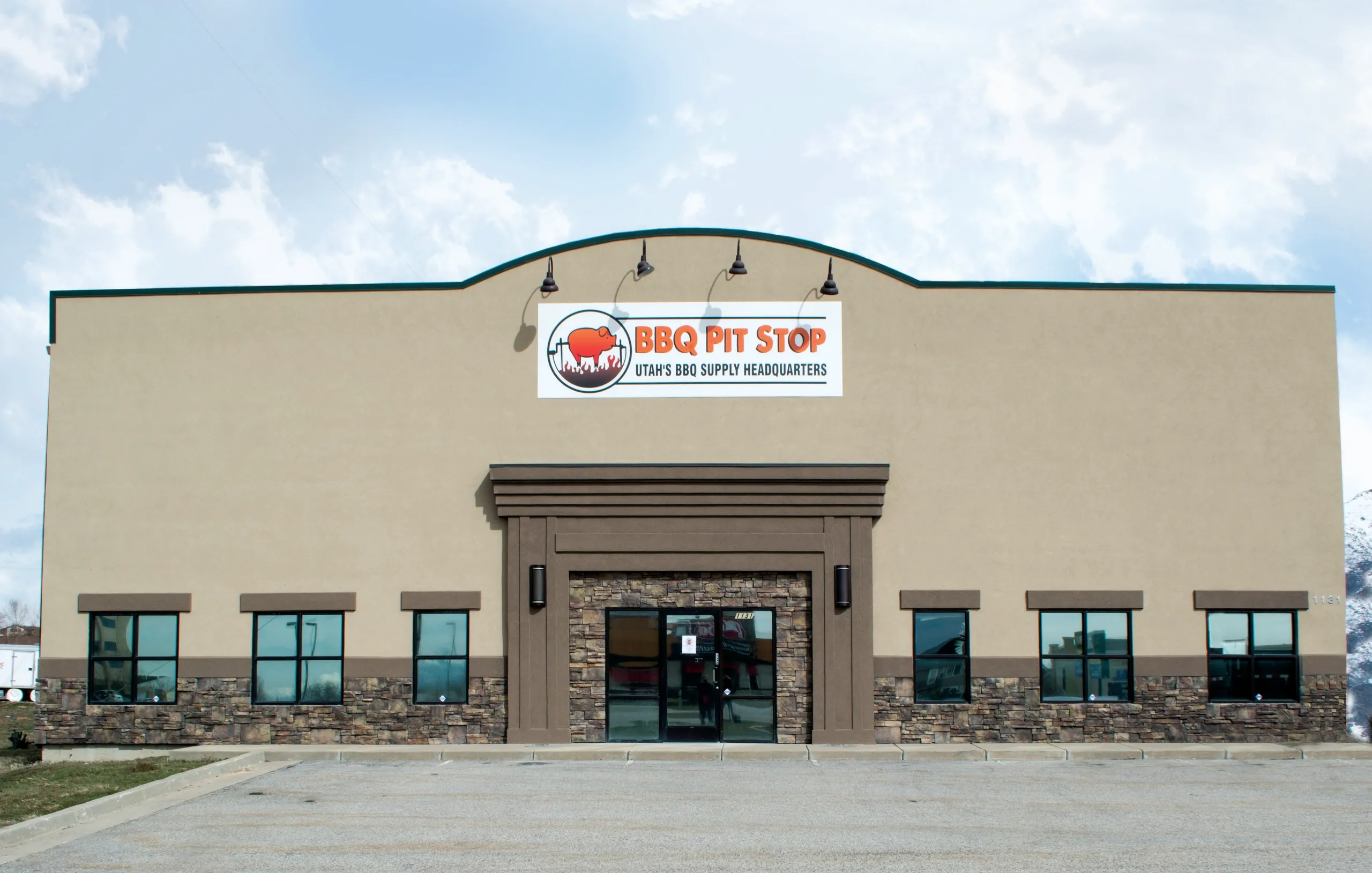Front view of a BBQ supply store with a sign reading 'BBQ Pit Stop.'