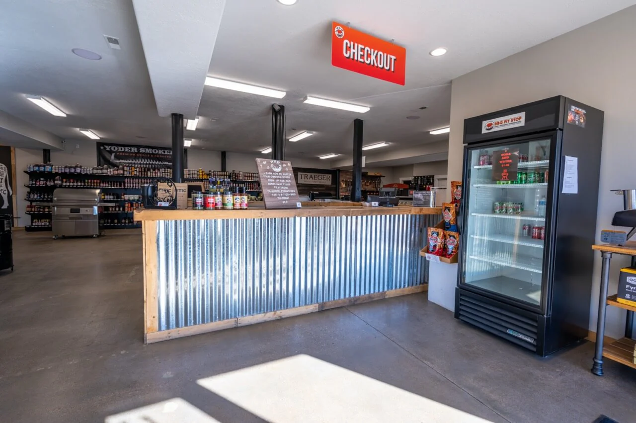 Store interior with checkout counter, shelves, and a refrigerator.