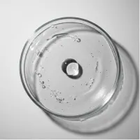Petri dish with clear liquid and a tablet dissolving.