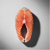 Raw salmon steak on a gray background.