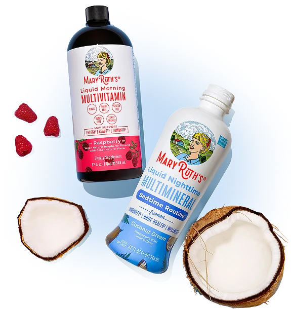 Two bottles of Mary Ruth's liquid vitamins are displayed with raspberries and a split coconut.